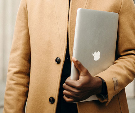 Black male carrying MacBook