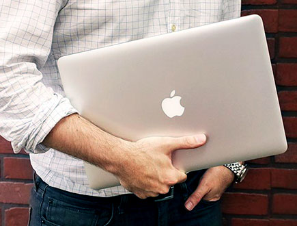 Male student holding Macbook