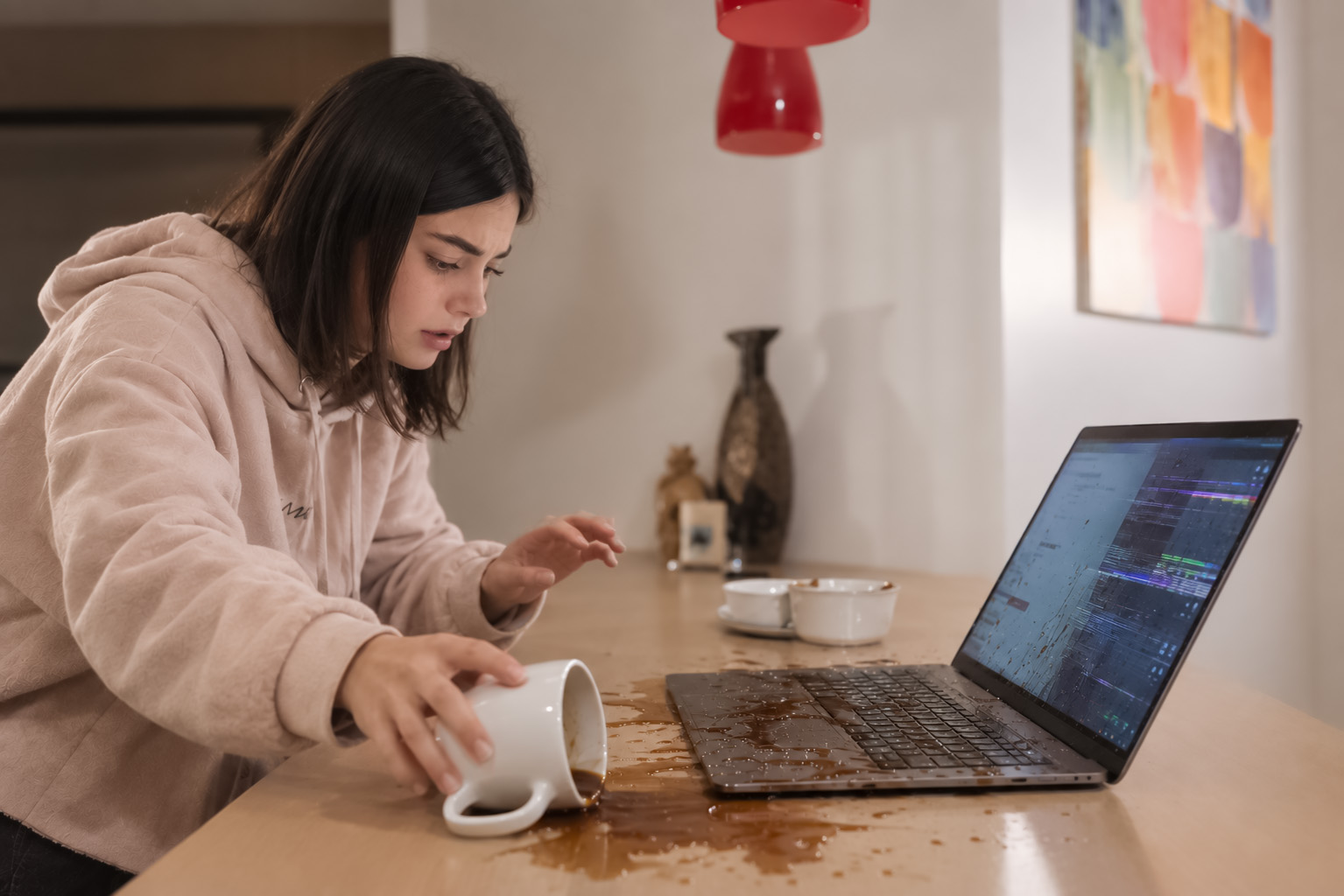 College student spilling coffee on a laptop